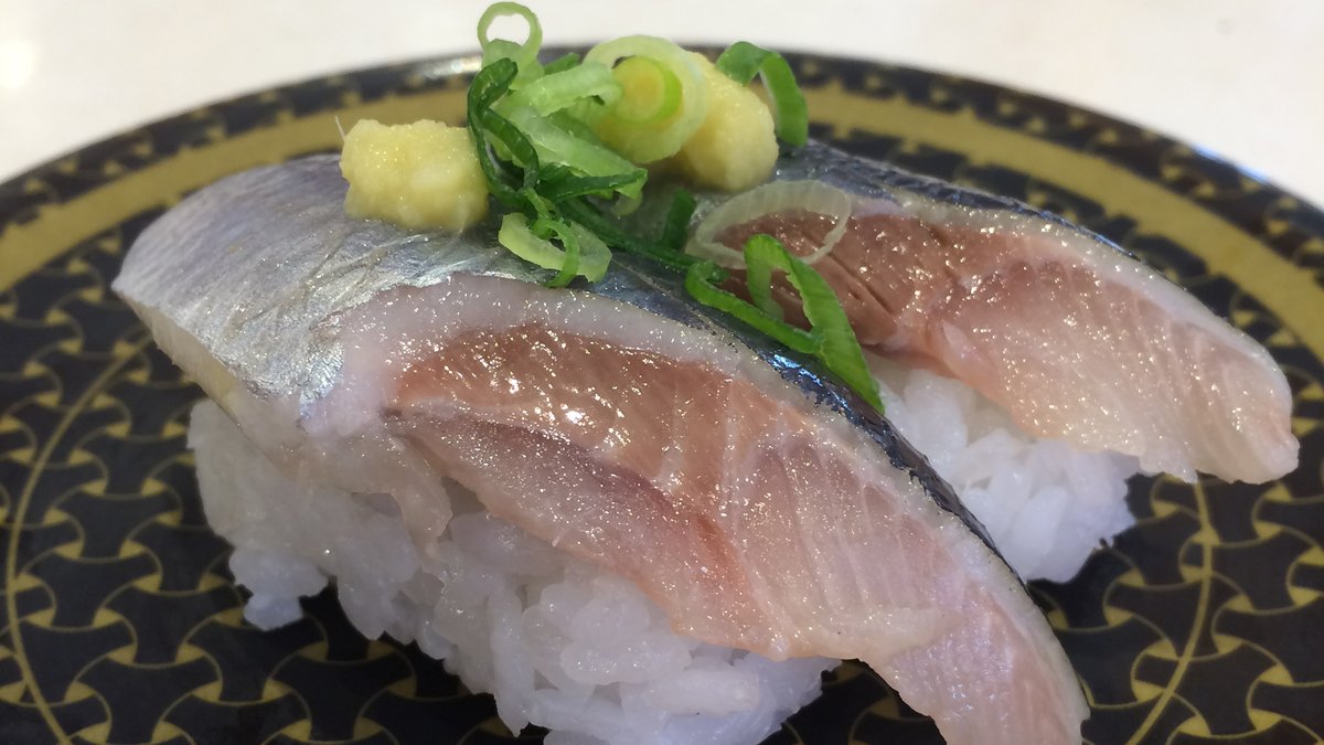 Sardine nigiri on a patterned plate at a Japanese kaiten sushi chain