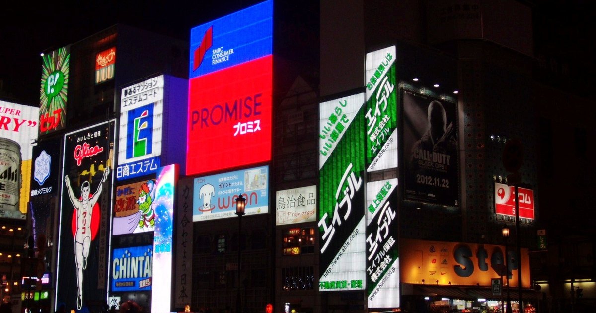 Wall of illuminated neon billboards over the Dotonbori canal at night