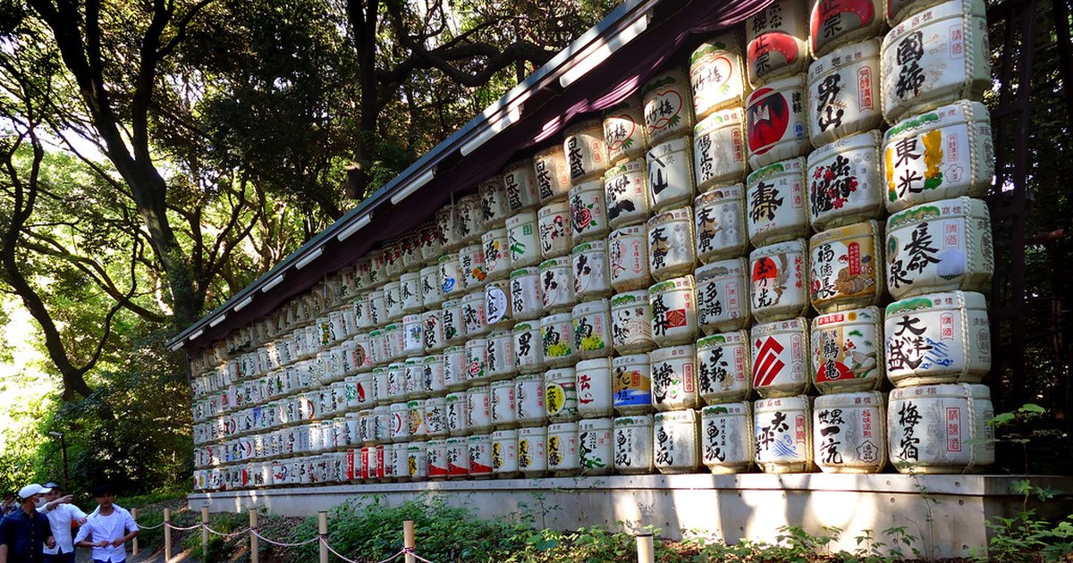 Wall of decorated sake barrels displayed along the approach to Meiji Jingu