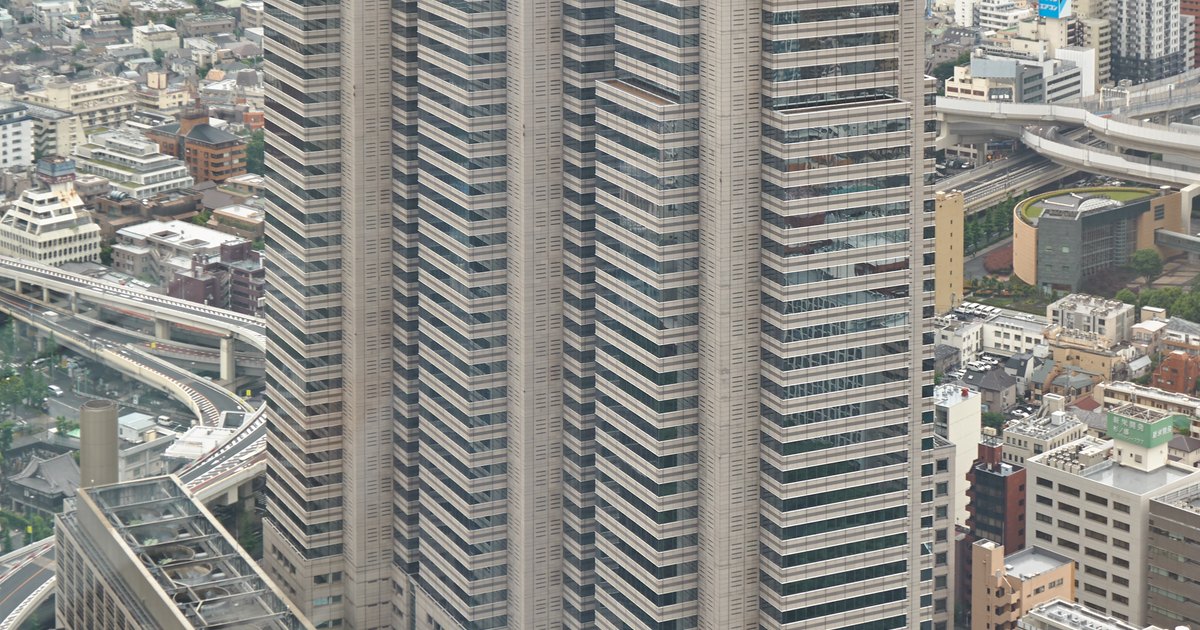 The three stepped peaks of Shinjuku Park Tower seen from above, with the city stretching behind