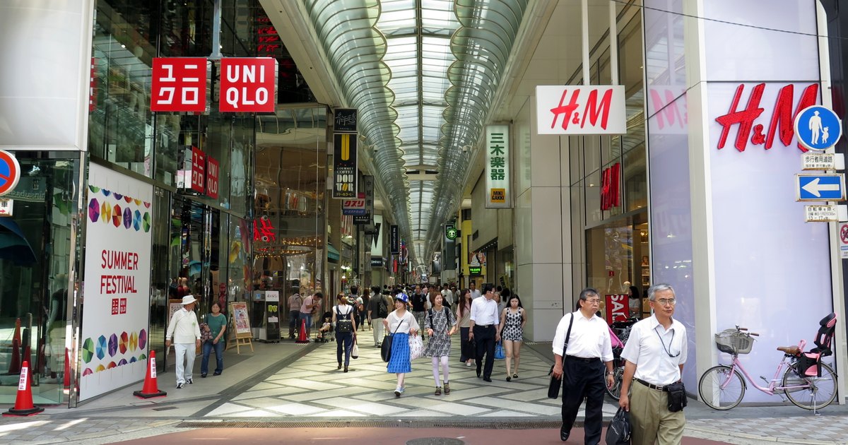 Covered Shinsaibashi-suji shopping arcade in daytime with shoppers walking under the glass roof