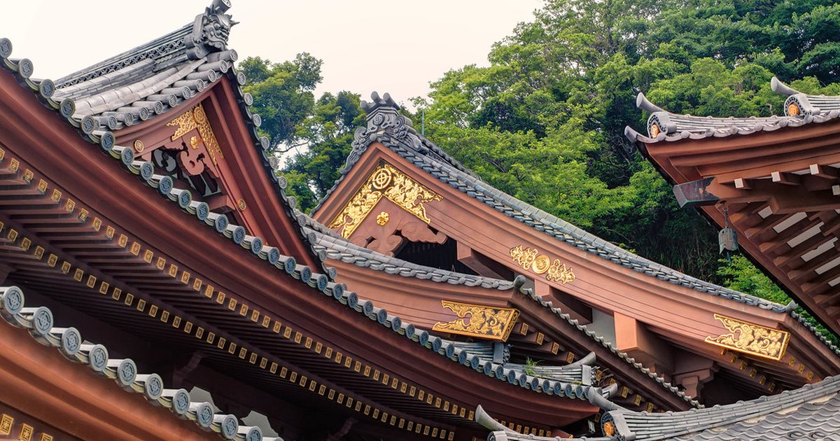 Layered temple rooftops with gilded ornaments at Hase-dera in Kamakura