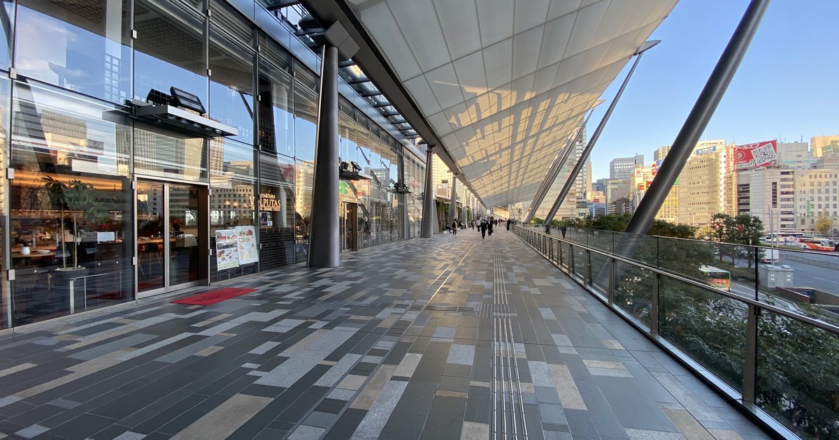 The covered pedestrian deck on the Yaesu side of Tokyo Station with office towers beyond