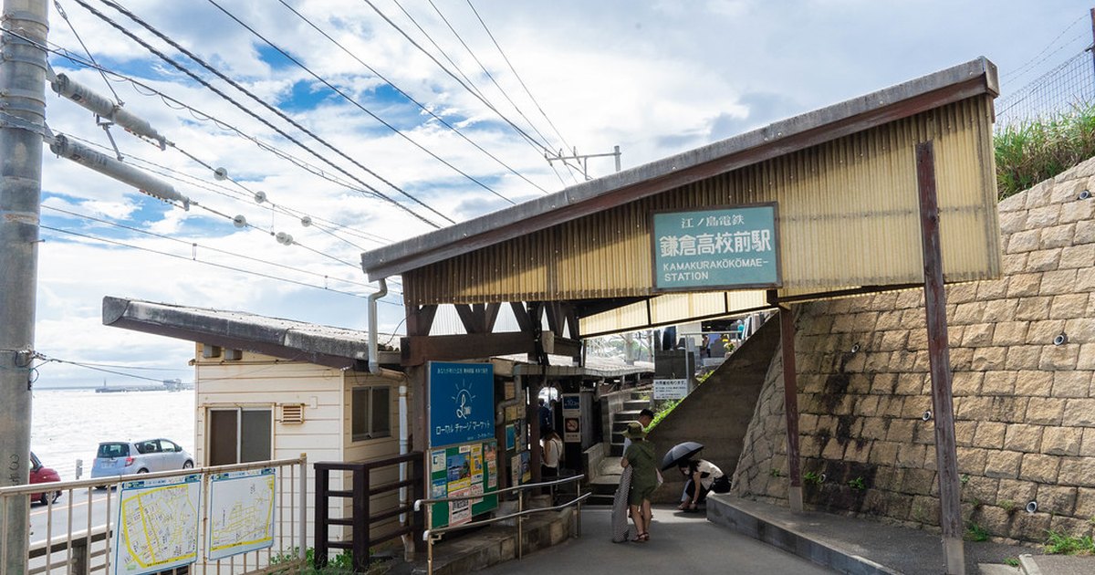 The small seaside entrance of Kamakurakokomae Station on the Enoden line with the bay behind