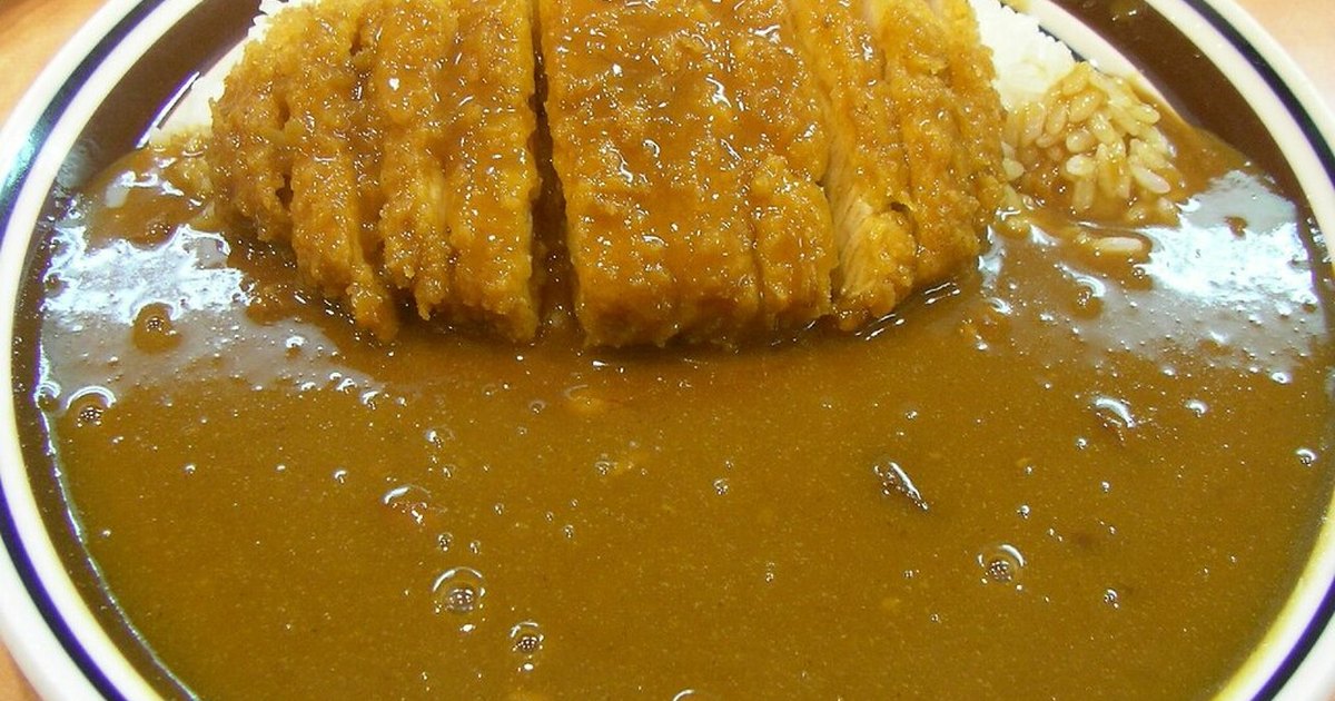 Plate of loin katsu curry at a Japanese curry restaurant, sliced pork cutlet over rice covered in brown curry sauce