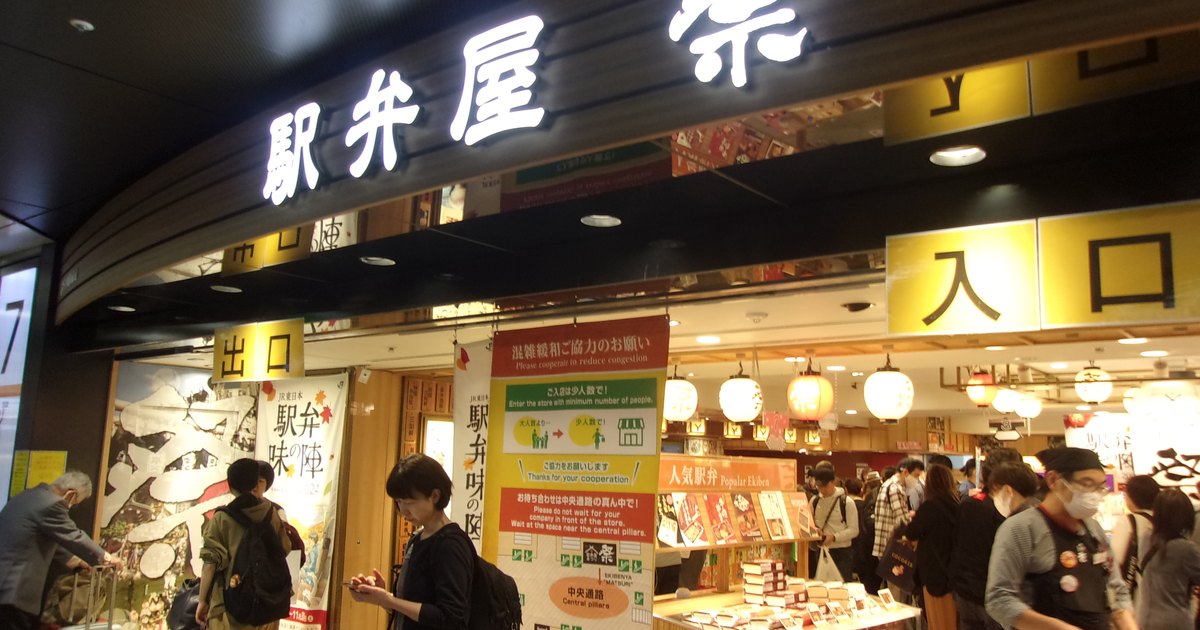 Entrance of the Ekiben-ya Matsuri bento hall inside Tokyo Station, with shoppers browsing boxed meals under illuminated signage