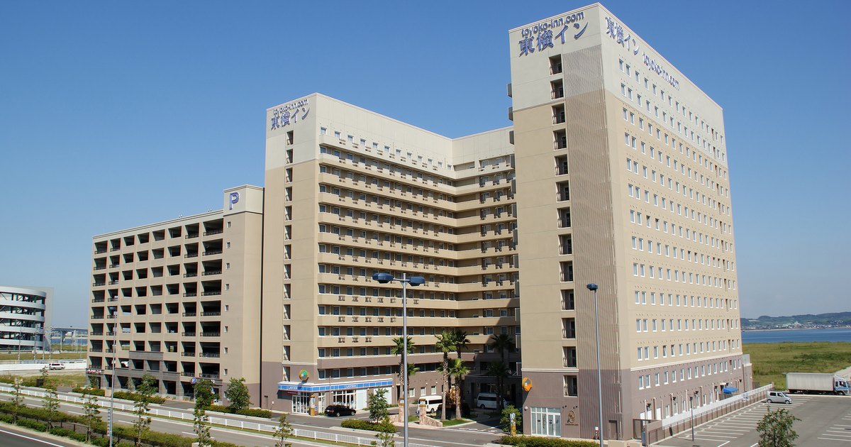 Toyoko Inn hotel building at Chubu Centrair International Airport, a beige tower with the chain's rooftop signage under a blue sky