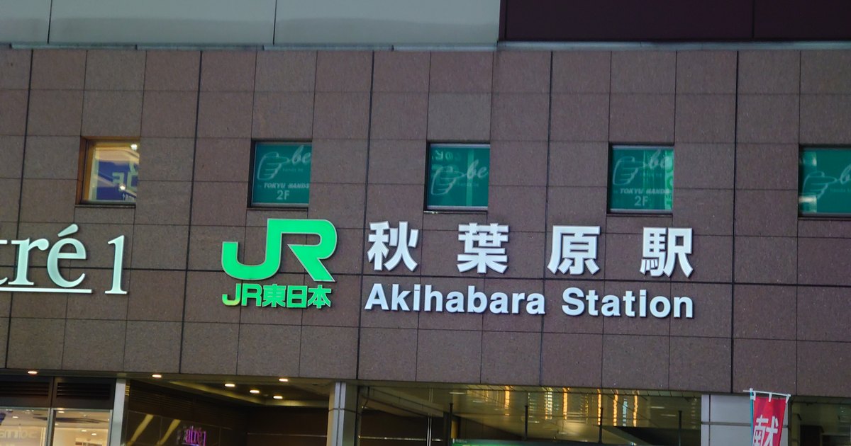 The illuminated JR Akihabara Station sign mounted on the station building at night