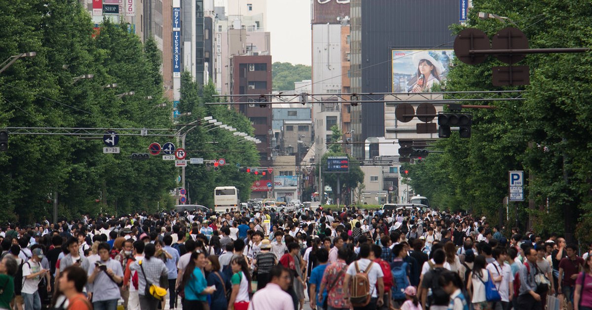 Crowds of pedestrians filling the full width of Chuo-dori in Akihabara during the Sunday pedestrian paradise, with the roadway closed to cars