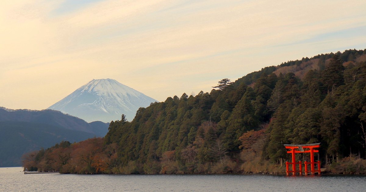 Lake Ashi in Hakone with a red torii gate standing in the water and Mount Fuji in the distance