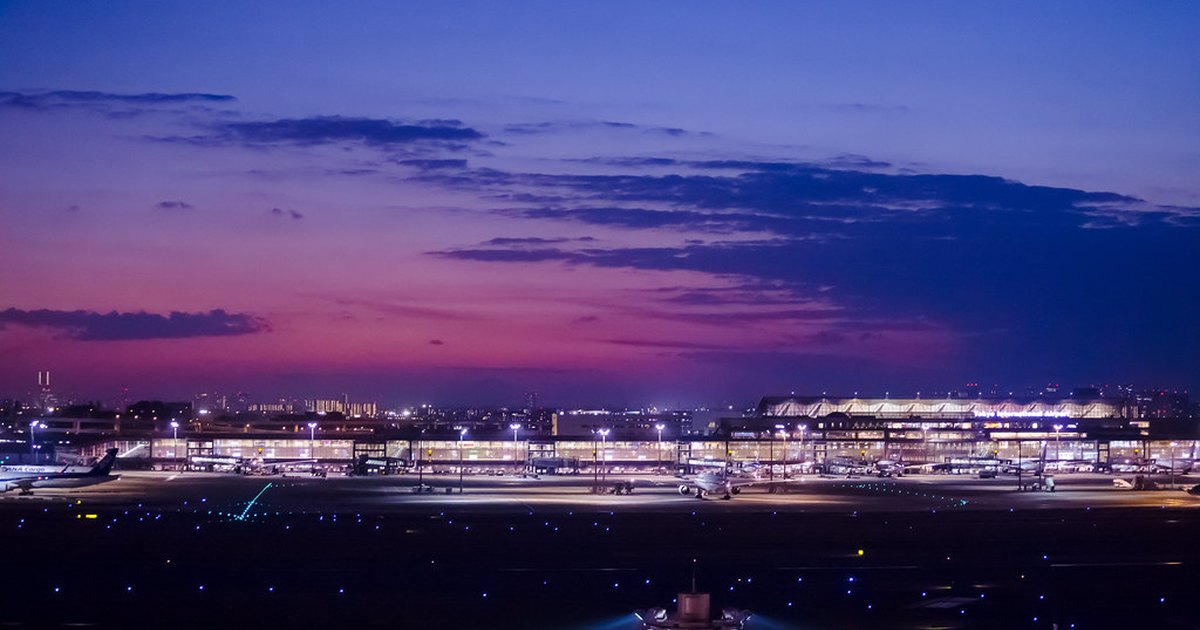Haneda Airport terminal and apron lit up at twilight with parked aircraft