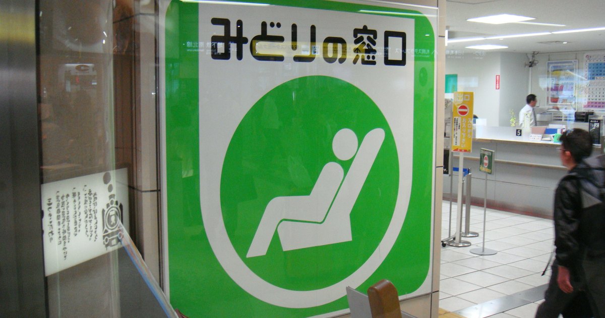 A large green Midori no Madoguchi sign at the entrance of a JR station ticket office