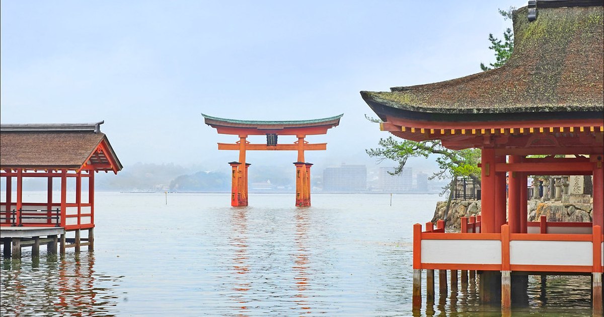 The vermilion torii gate of Itsukushima Shrine standing in the water at high tide on Miyajima