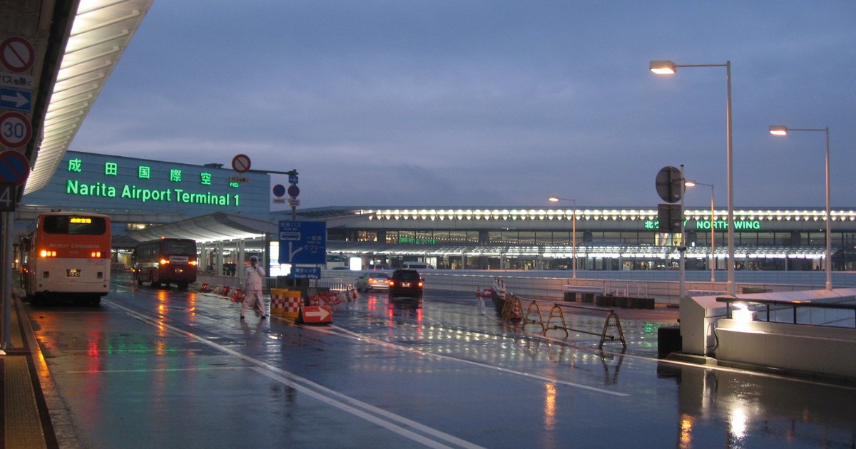 Buses waiting in the curbside bus lanes outside Narita Airport Terminal 1 at dusk