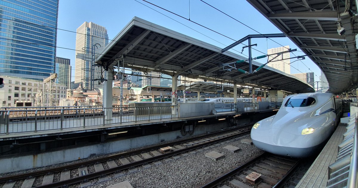 A white shinkansen train standing at a covered platform at Tokyo Station