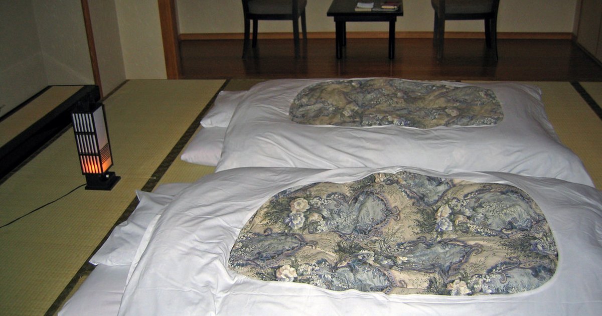 Two futon bedrolls laid side by side on the tatami floor of a Japanese-style room
