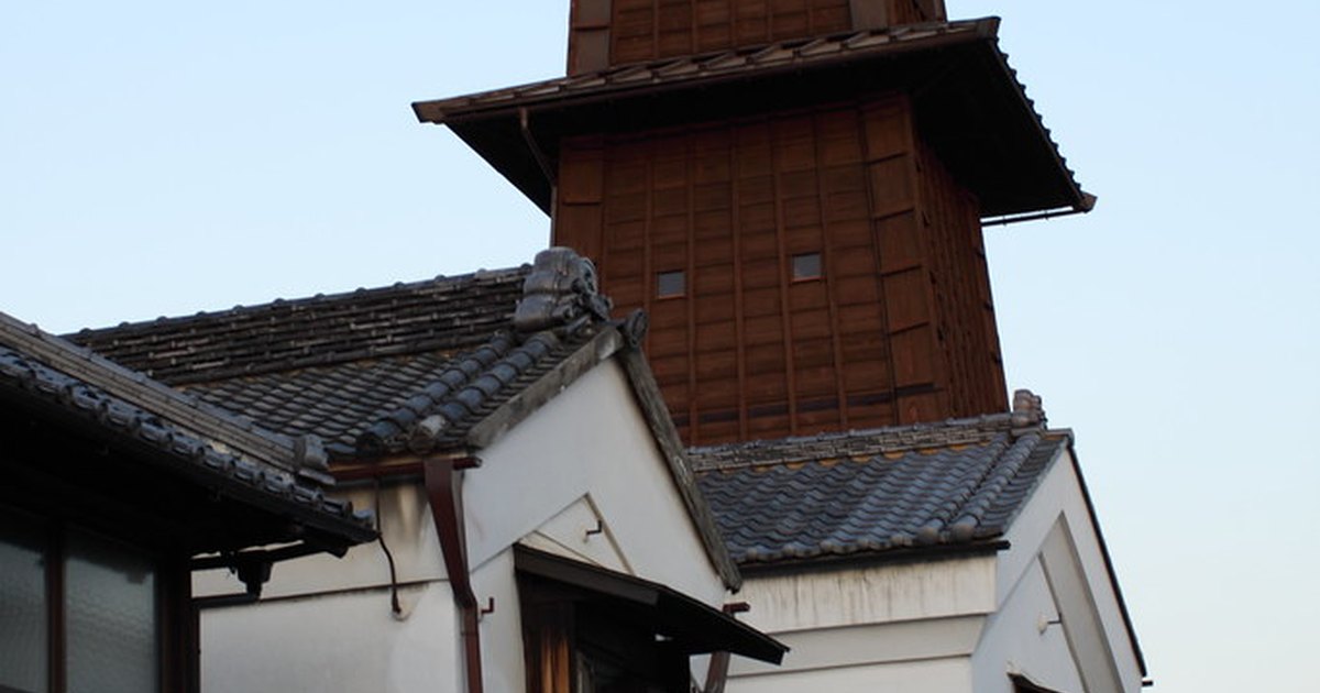 The wooden Toki no Kane bell tower rising above tiled roofs of clay-walled kurazukuri merchant houses in Kawagoe