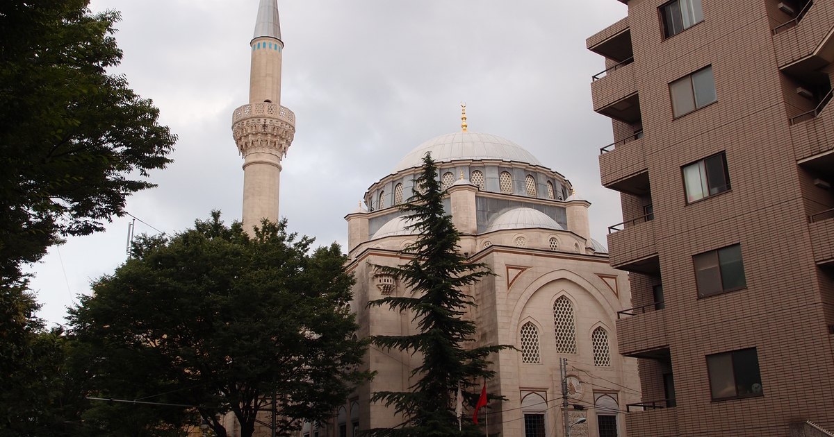 Exterior of Tokyo Camii mosque in Yoyogi-Uehara with its white Ottoman-style dome and slender minaret beside an apartment building