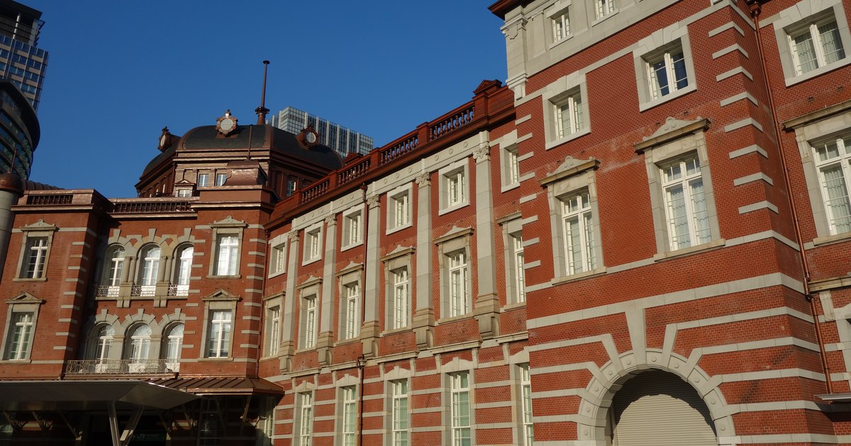 The red brick facade of the restored Marunouchi building at Tokyo Station under a blue sky