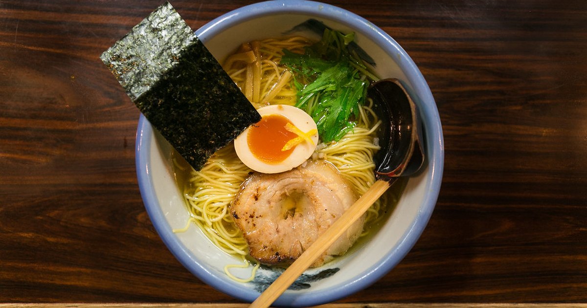 Overhead view of a bowl of clear shio ramen with thin noodles, seared pork, egg and nori
