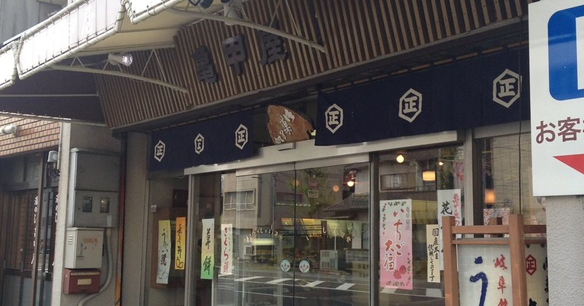 Traditional Japanese wagashi shop storefront with an indigo noren curtain and seasonal paper signs