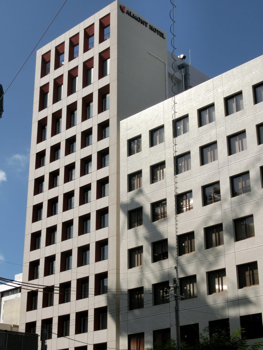 Exterior of Almont Hotel Naha Kenchomae, a white building with a red window grid