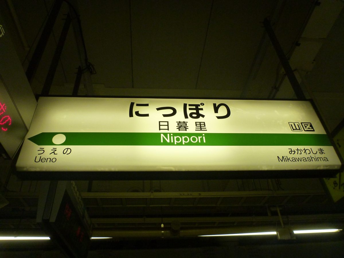 Station sign for Nippori on a JR platform