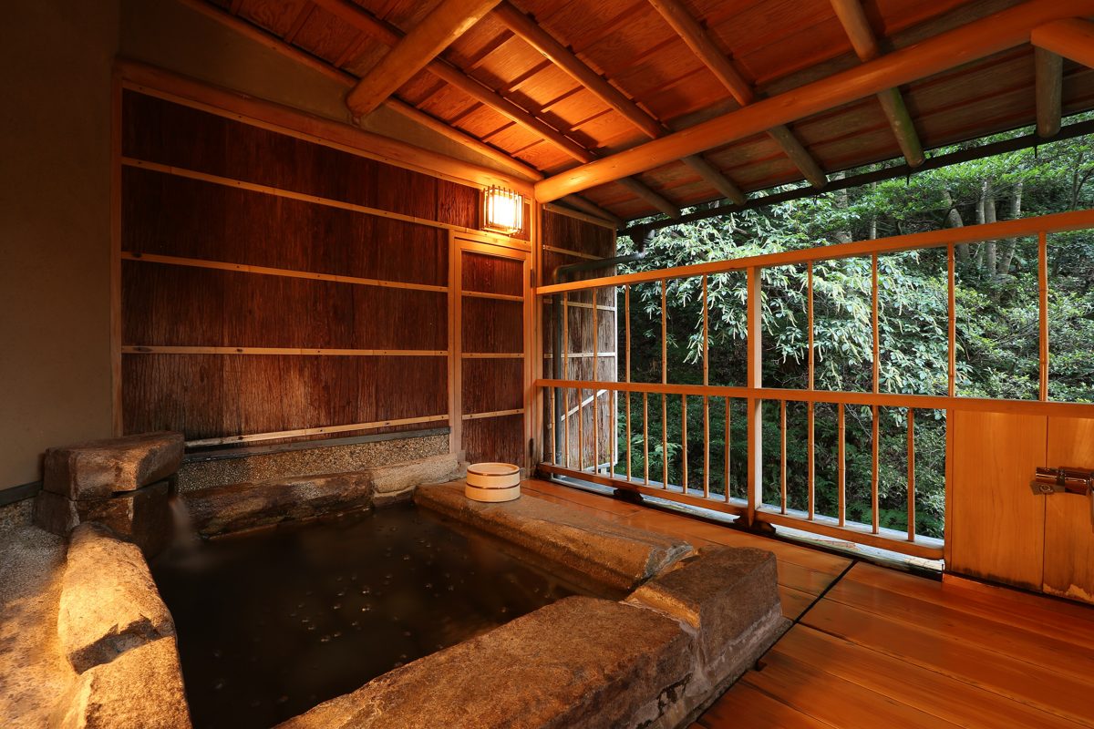 Indoor wooden bath at a Japanese hotel with a large window
