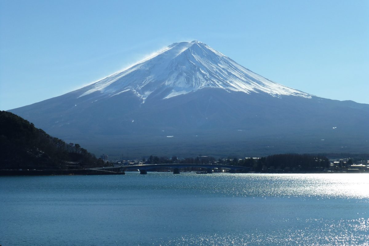Snow-capped Mount Fuji above the blue water of Lake Kawaguchiko