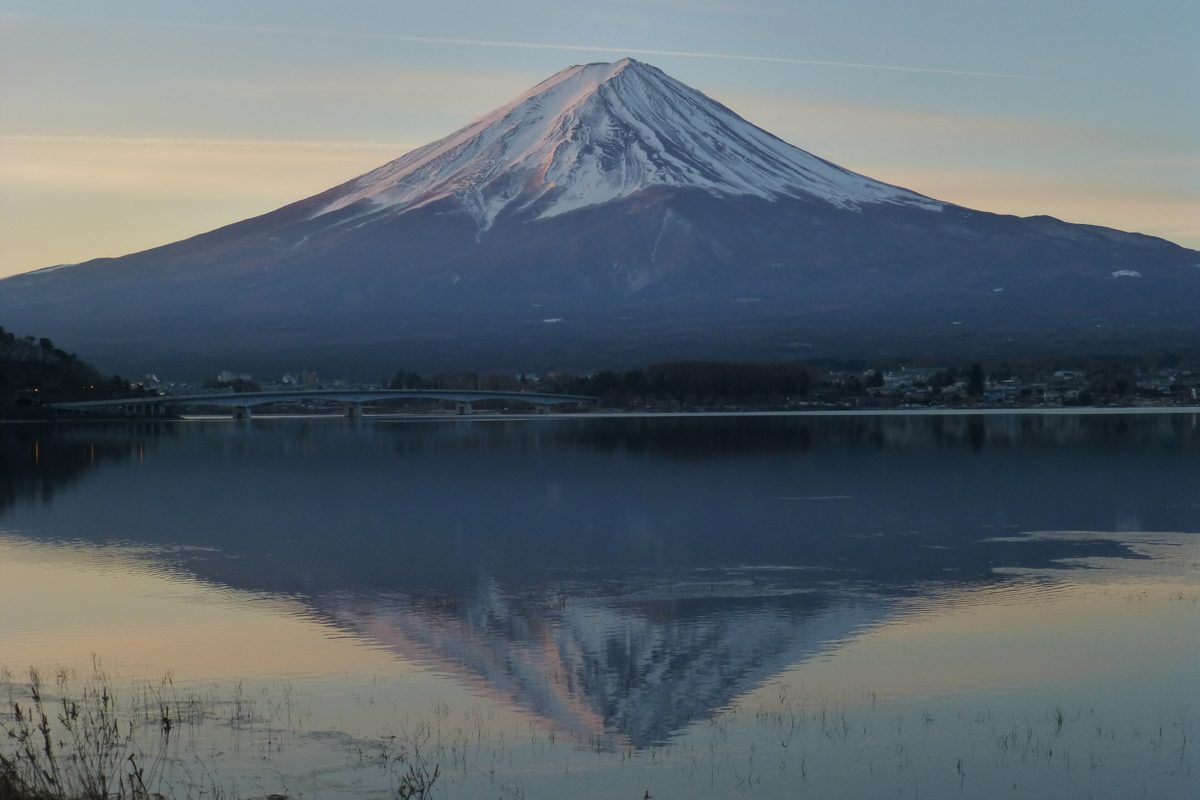 Mount Fuji reflected in still Lake Kawaguchiko at dusk