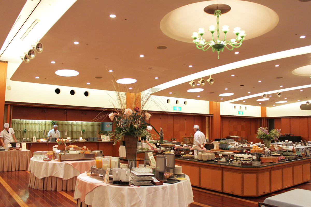 Buffet counters with Japanese and Western dishes in a large hotel breakfast room