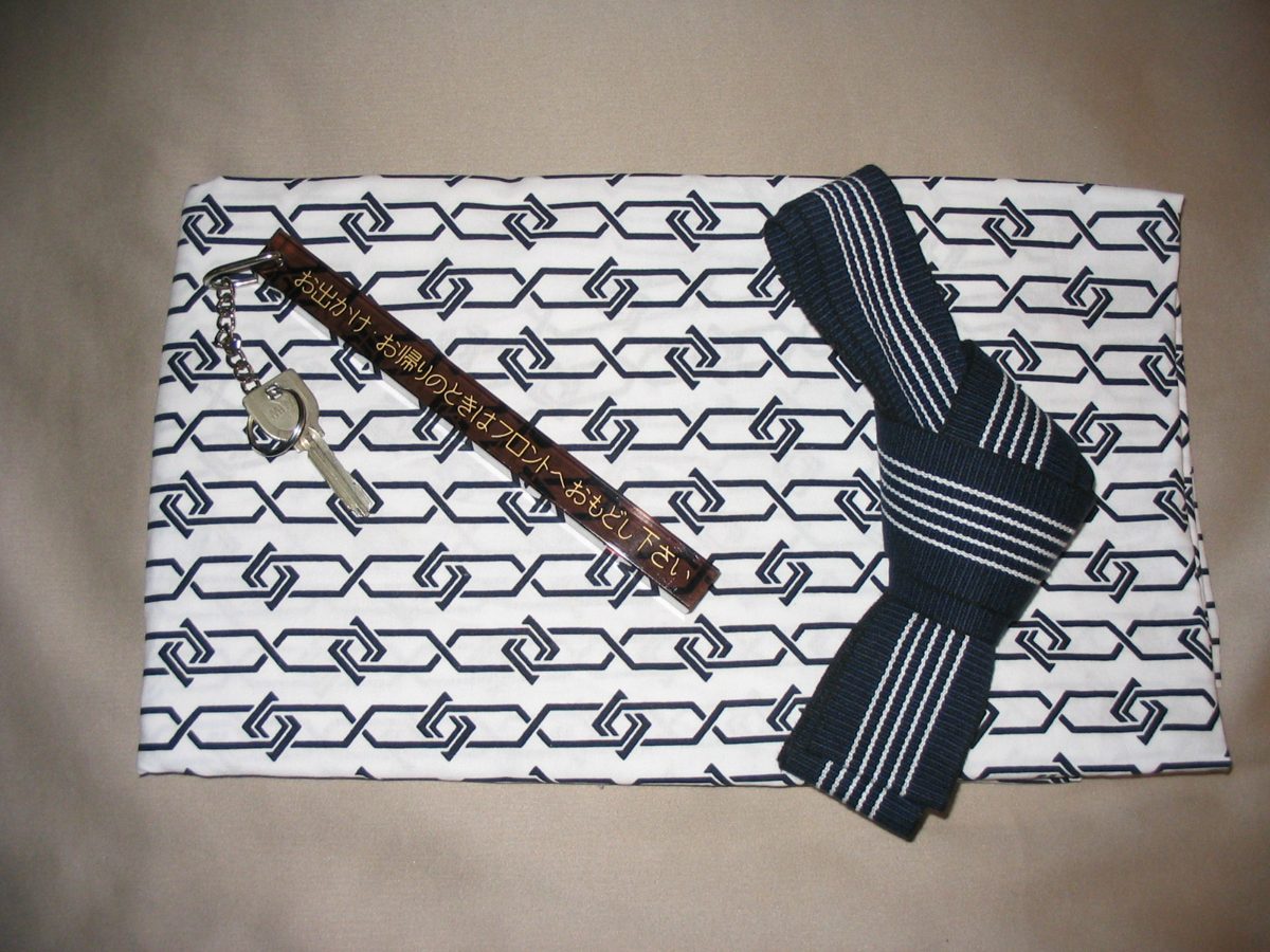 A folded yukata and a hotel room key in Japan