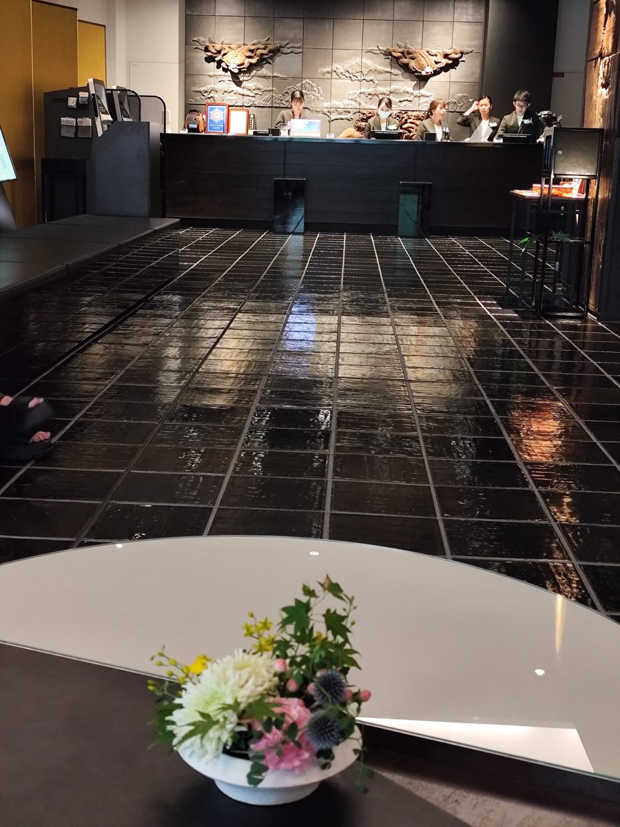 A dark hotel lobby in Kyoto with a front desk