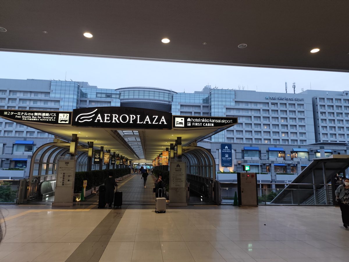 The covered AeroPlaza footbridge at Kansai International Airport, with a hotel building behind it