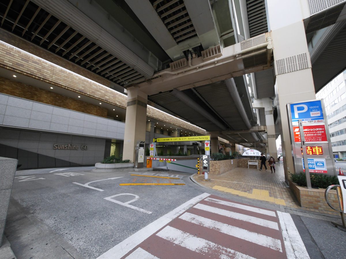 The entrance to Sunshine Parking in Ikebukuro, Tokyo, with height limit signs over the gate