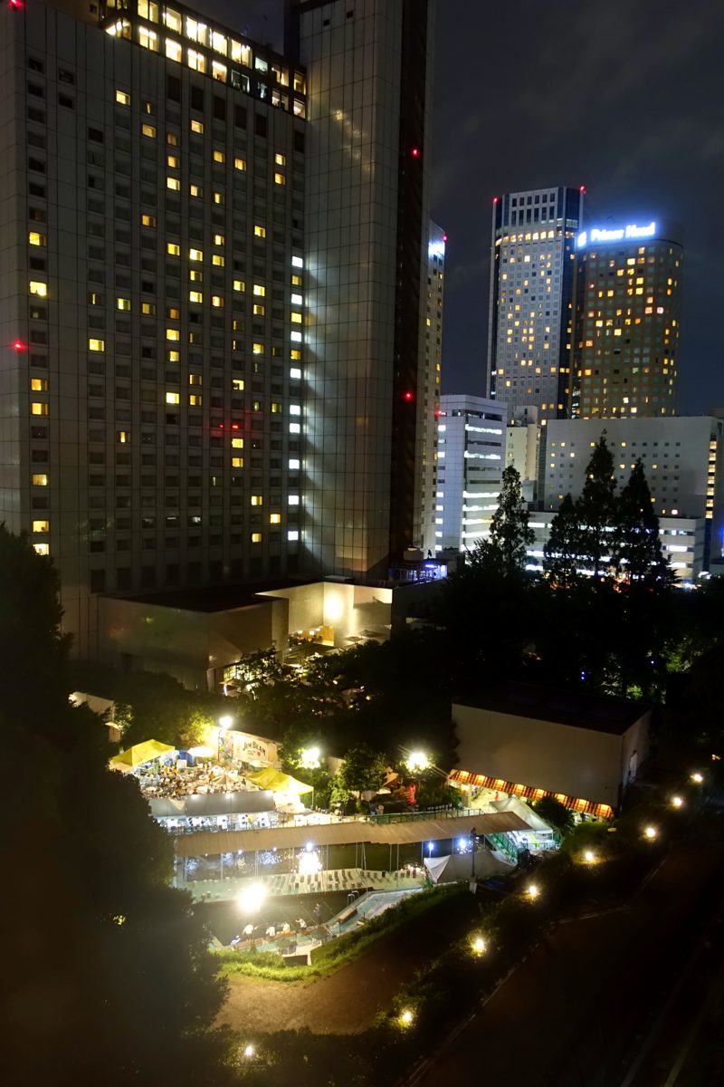 Shinagawa Prince Hotel towers lit up at night above a lit garden