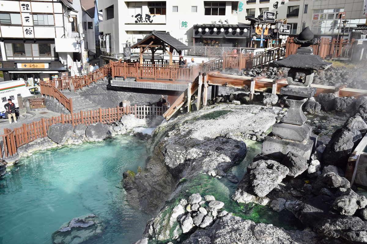 Turquoise hot spring water and wooden channels at the Yubatake in Kusatsu Onsen