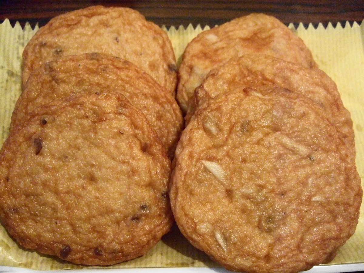 Several round golden fried fish cakes on paper