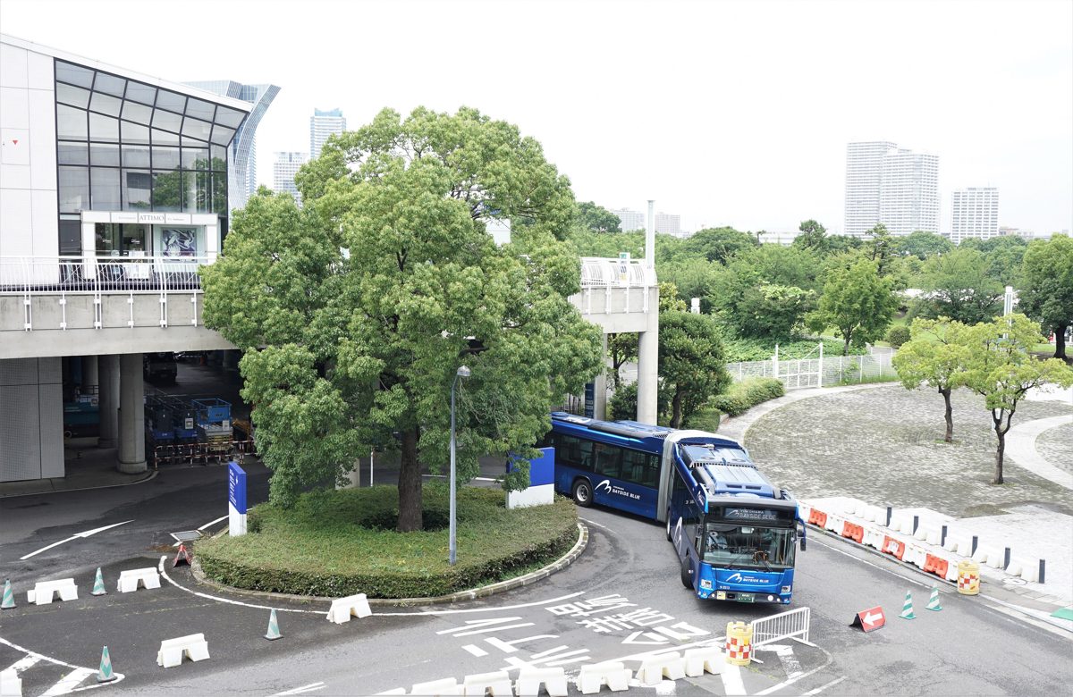 A blue BAYSIDE BLUE articulated bus turning at the Pacifico Yokohama bus stop
