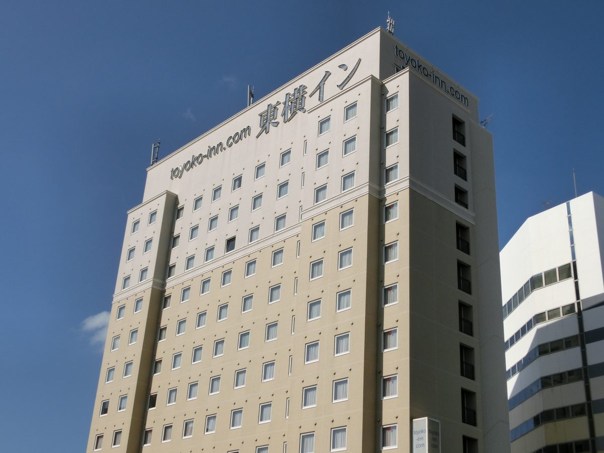 Exterior of a Toyoko Inn business hotel under a blue sky