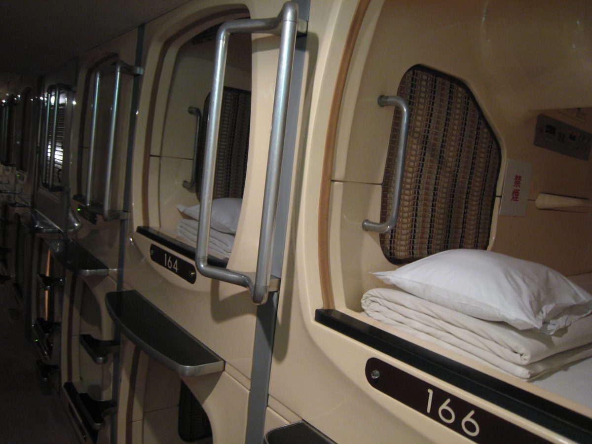 Inside a capsule hotel unit with bedding