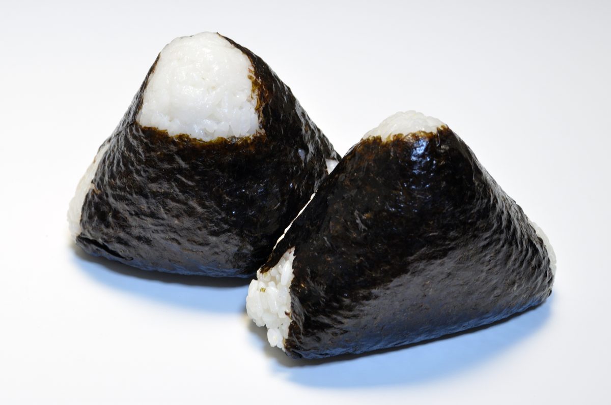 Two triangular onigiri fully wrapped in dark nori seaweed