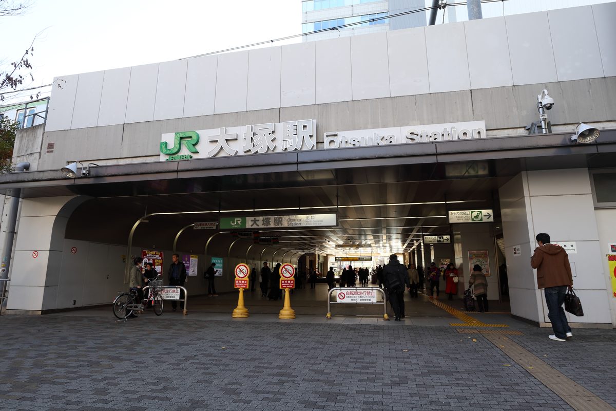 The north exit of JR Otsuka Station with its station name sign