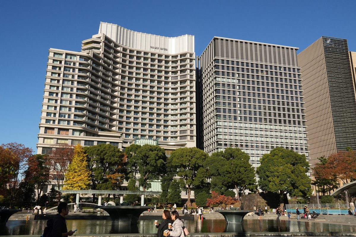 Palace Hotel Tokyo, a pale stone tower, beside Nippon Life Marunouchi Garden Tower, with fountains and autumn trees in front