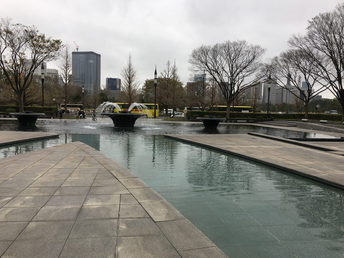 Stone paving, a long reflecting pool and fountains at Wadakura Fountain Park in Marunouchi