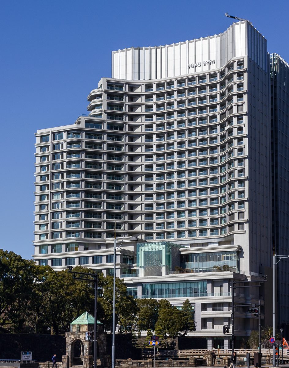 The curved facade of Palace Hotel Tokyo with its name at the top, seen from the street