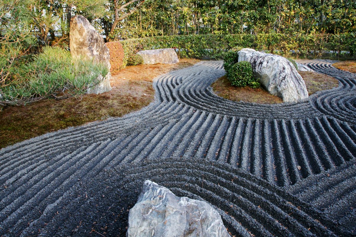 A dry rock garden of raked dark gravel and large stones