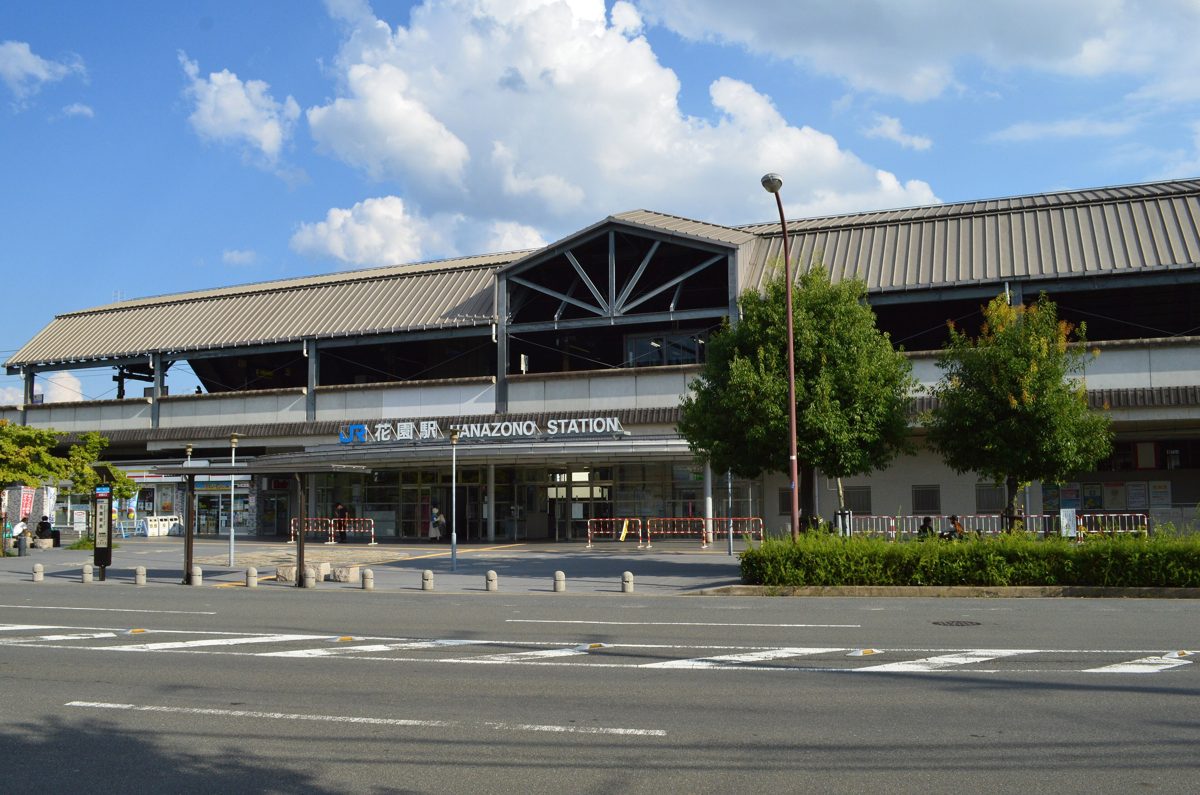 The front of JR Hanazono Station in Kyoto under a blue sky