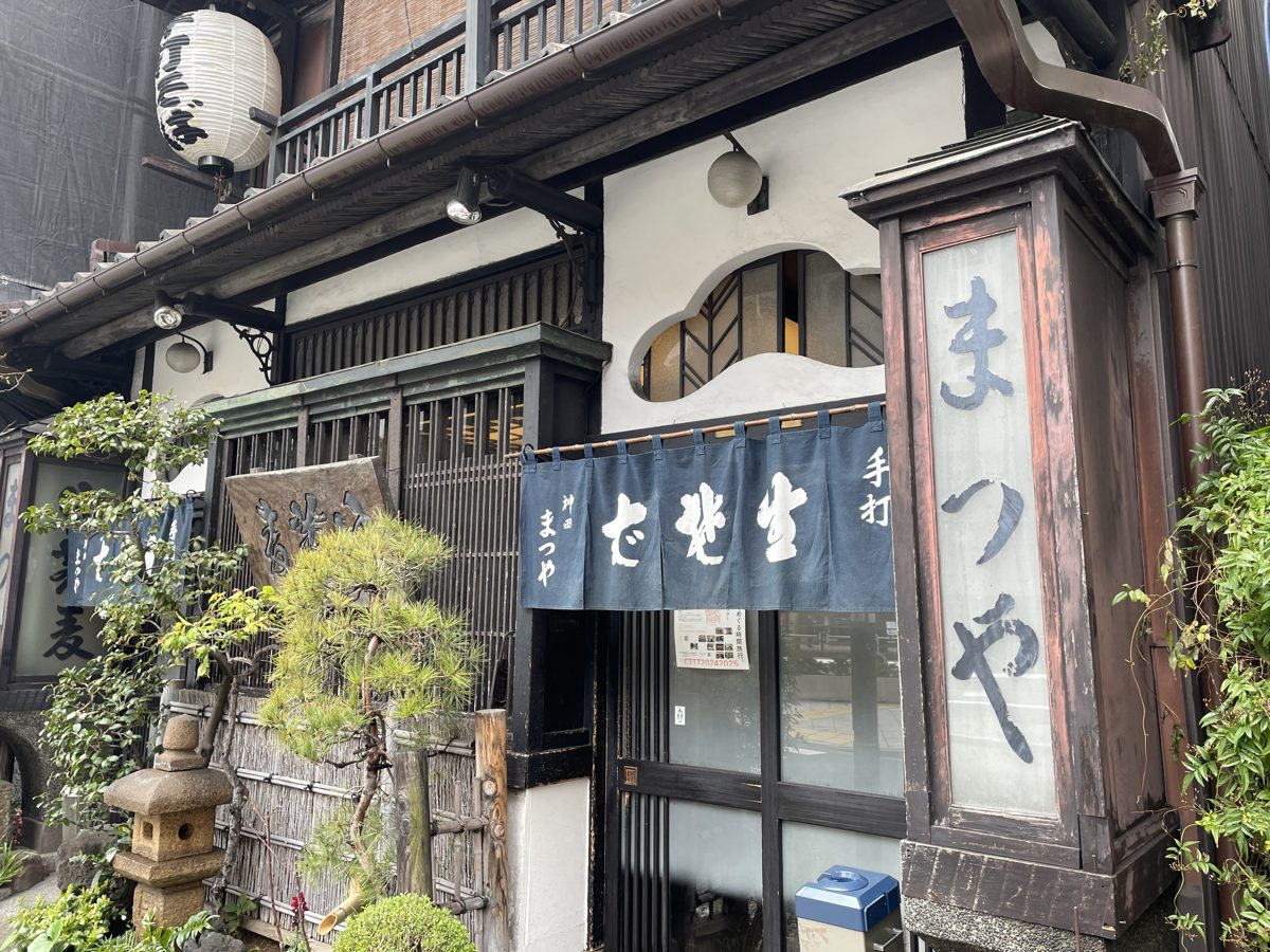 The wooden front of Kanda Matsuya with its vertical name sign and noren curtain