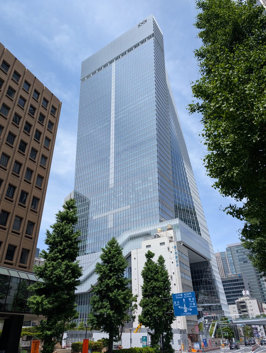 Toranomon Hills tower seen from a tree-lined street